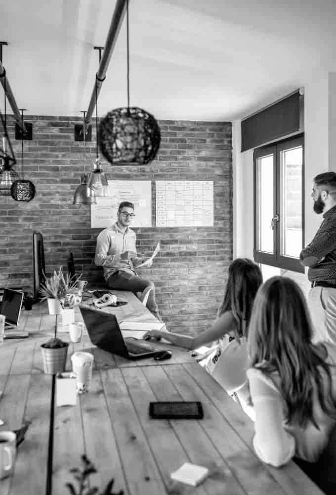 startup ceo giving a talk to workers in a shared office